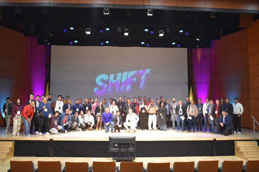 Everyone on stage under the SHIFT logo at the close of the Forum