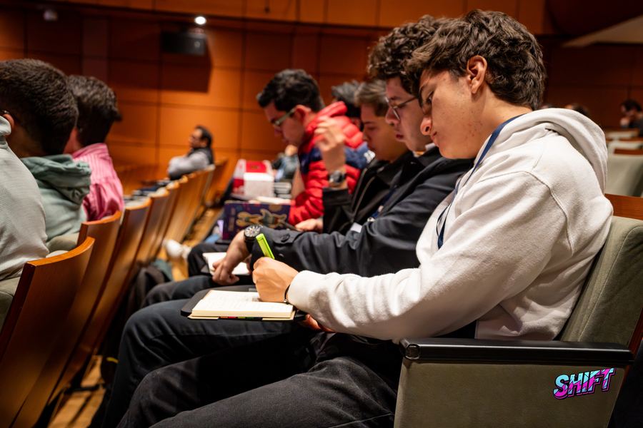 Estudiantes tomando notas en el público