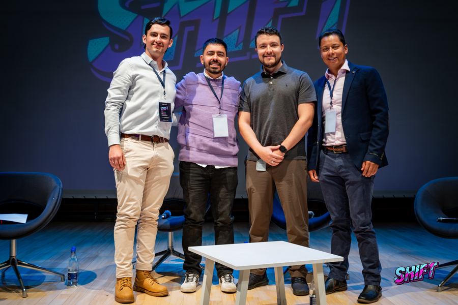 Foto grupal del panel frente al logo de SHIFT