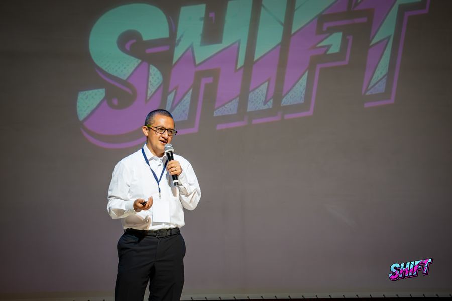 Conferencista con el logo de SHIFT detrás